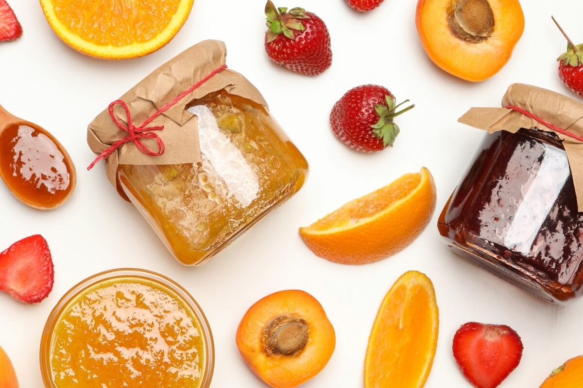 Vasetti di marmellata e composta di frutta con fragole albicocche e arance